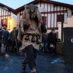 Carnaval en pays basque : danseur avec peau et sonnailles, cortège dans un village