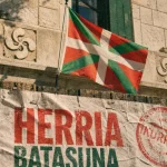 Drapeau pays basque ikurriña sur façade basque avec lauburu et croix basque