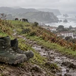 Randonne pays basque : chaussures de randonnée sur sentier humide vers la crête